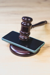 Judge Hammer for adjudication with wooden stand and smartphone on it. Auction or Lawyer decision....