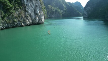 Drone footage of the tourists kayaking in the tranquil water of Lan Ha Bay in Cat Ba island, Vietnam