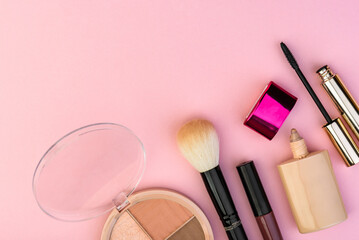 Makeup cosmetic products on pink background.