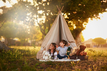 Teepee, kids and fun in garden tent outdoor in nature for camping, playing and adventure with...