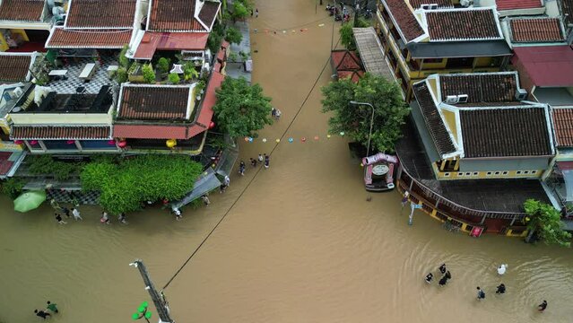 Aerial footage of people walking in water-flooded streets after floods in Hoi An town, Vietnam
