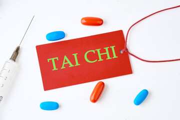 The words Tai Chi concept and theme written on a red card on a light background with pills in the...