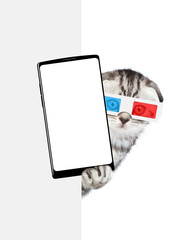 Cute tabby kitten wearing 3d glasses holds big smartphone with white blank screen in it paw, showing close to camera behind empty white banner. Isolated on white background