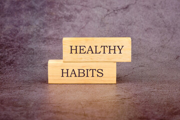 Business and Healthy habits concept. Concept word Healthy habits written on wooden blocks on a dark...