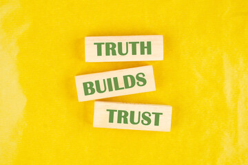 Truth builds trust symbol. Concept words Truth builds trust on wooden blocks on a yellow background