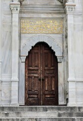 Rustic wooden door stands open, flanked by a stone staircase in Istanbul, Turkey.
