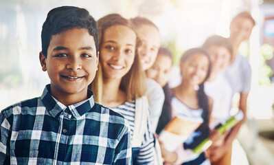 Boy, portrait and group of students in line at school with smile, confidence and scholarship outdoor. Children, friends and happy or waiting in row outside classroom for education, study and learning