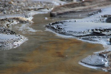 there is a puddle of mud in the middle of the water