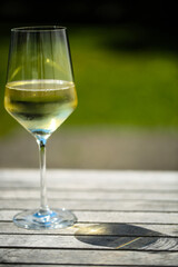 glas of white wine on golden tablet, in the garden