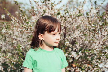 Happy peaceful child girl on the background of a blooming tree. The concept of mental health,...