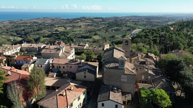 Drone footage of Novilara hamlet with green fields and Mediterranean sea in the background, Italy