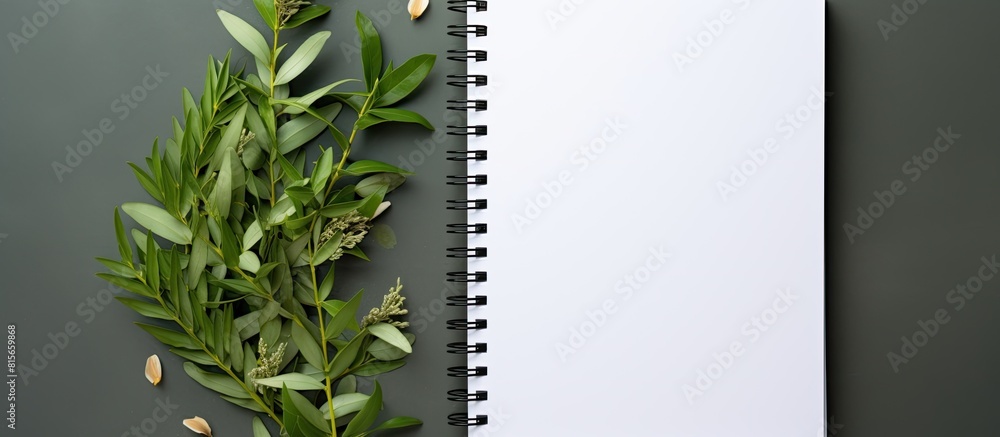 Fototapete a notebook with a white page and copy space image adorned with curry leaves