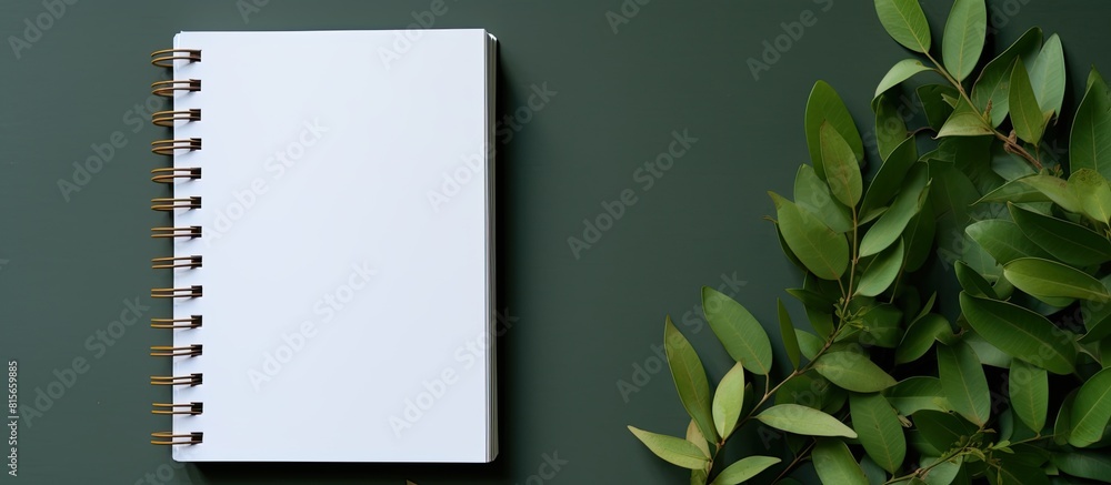 Poster a notebook with a white page and copy space image adorned with curry leaves