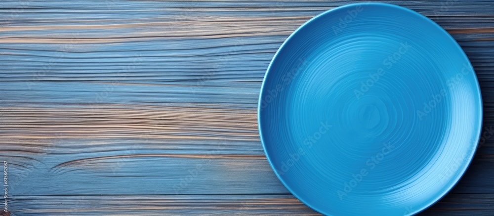 Poster Top view of empty blue plate on wooden background Empty space for your design. copy space available