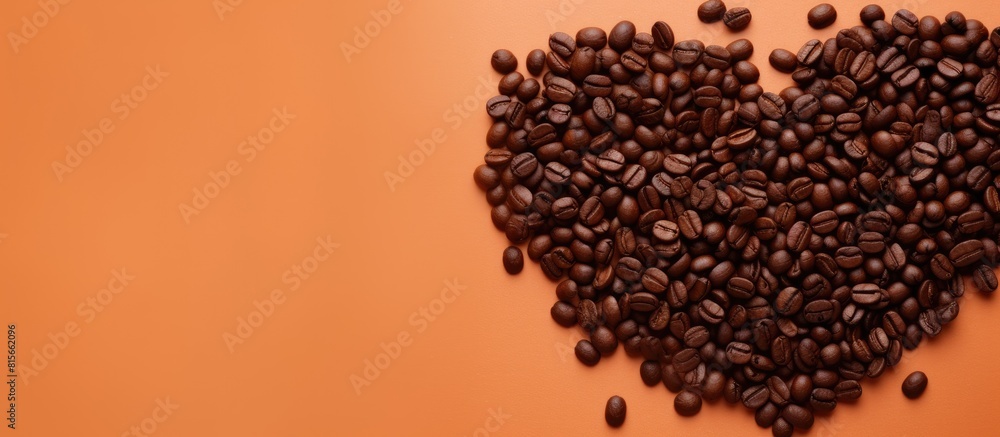 Poster top view of a light orange background featuring a heart shaped pile of coffee beans providing ample 