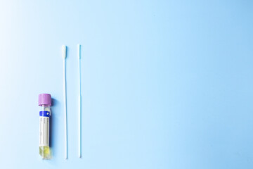 A syringe and a swab are on a blue background