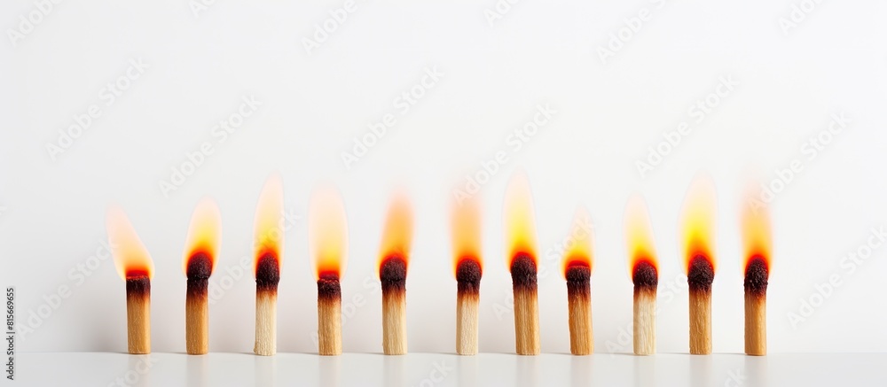 Poster A copy space image of a row of three matches one of which is lit burning on a white background