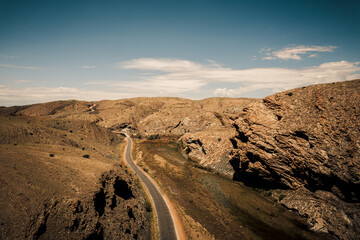 a car driving on a road in the middle of the desert