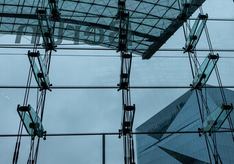 the reflection of three skyscrapers on glass wall in a large atrium