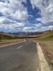 an empty road stretching into the mountains, in this scene