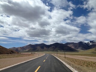 the road is narrow and empty in the mountains surrounding the valley