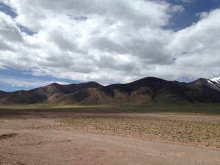 a desert area with mountains and a dirt road below it