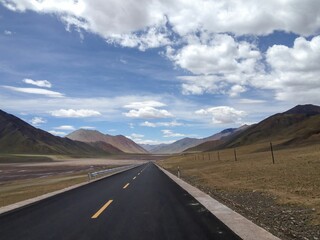 an empty open road through the mountains on a clear day