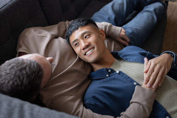 Gay couple at home relaxing on a sofa together