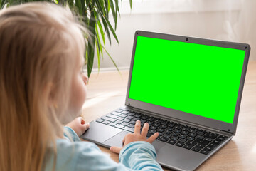 preschool girl studying distance learning course, using computer, monitor with green screen mockup, self-education and entertainment, Parenting in digital age, cyber education, screen time