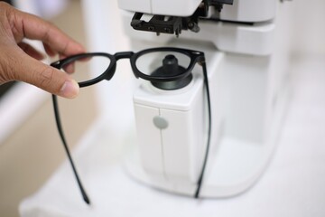 Hand holding glasses in eyeglasses store