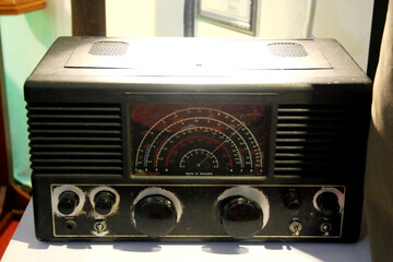 An old British-made transistor radio sat in the corner of a dark room with sunlight shining through the window.