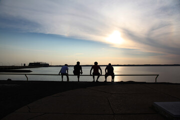 Fototapeta premium Four people sitting by the river at sunshine