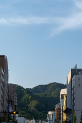 街中のビルの合間から望む山並み