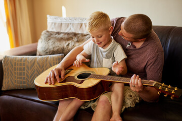 Father, child and learning guitar in home or musical instrument for teaching, bonding or song. Man,...