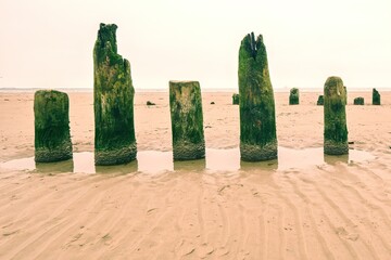 Ruined wooden pier leading towards the sea on the horizon.