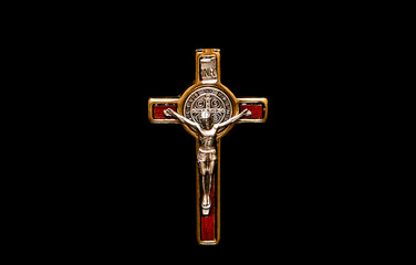 A close up of a metal crucifix on a black background