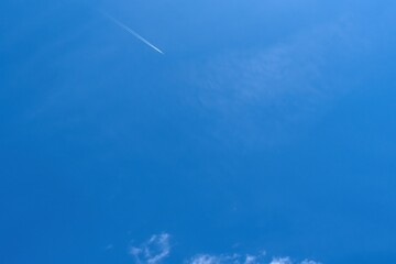Airplane with contrails in the blue sky.