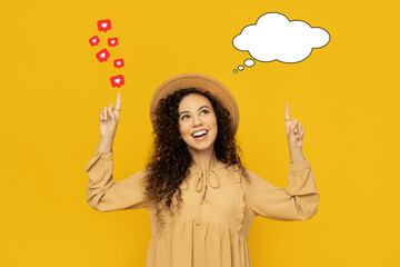 Young woman on yellow background with talk cloud and like hearts