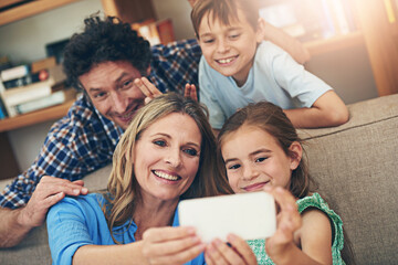 Happy family, relax and selfie with peace sign for memory, picture or bonding together on sofa at home. Mom, dad and young children with smile for photography, capture or moment on living room couch