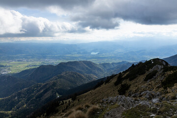 Fototapeta premium Begunjščica panorama of mountain trekking to the highest peak. View of the Alps, climbing with via ferrata. Distant view of Lake Bled from above. Sports holidays, life of adventure in the countryside