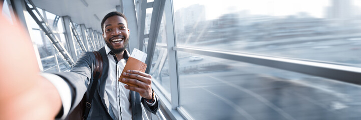 Happy African American Businessman Taking Selfie In Airport, Holding Passport With Tickets,...