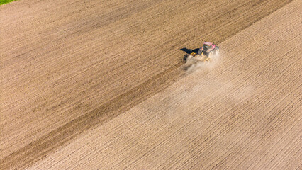 Tractor working in agriculture fields, aerial drone view