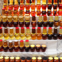 Various honey in glass jars on the shelves. Street trading in tourist areas.