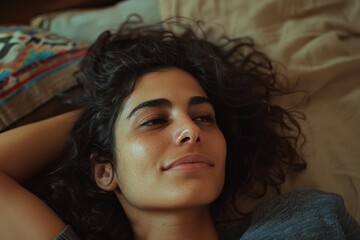 Portrait of a relaxed woman lying on a bed, feeling peaceful and content. Comfortable and serene atmosphere with natural lighting.
