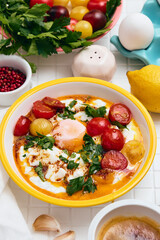 Cilbir or Turkish Eggs in white bowl. Turkish cuisine concept.