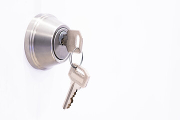Door lock and key hanging in the lock on a white background