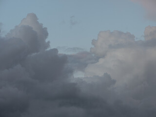 a dark cloud is creeping over the blue sky