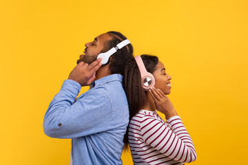 African American man and woman are shown wearing headphones, listening to music. They appear...
