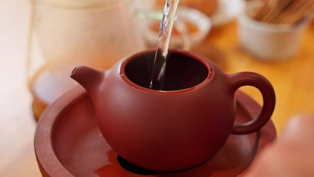 Brewing Chinese tea / Hot water pouring into clay teapot