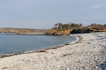 En automne, sous un ciel bleu clair, la plage de galets de la presqu'île de Crozon dévoile toute sa sérénité.